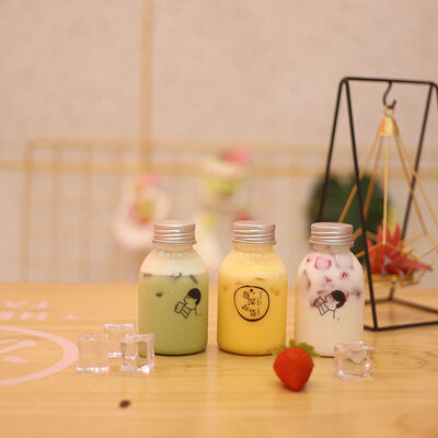 กระป๋องชานมพลาสติกที่มีมือและสกรูบนฝาแก้วบรรจุเครื่องดื่มที่มีการจัดการที่สะดวกสบาย